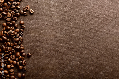 Roasted coffee beans on grey textile background