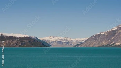 Wallpaper Mural Time lapse view of green, rocky, snow capped mountains surrounded by glassy blue water, Alaska. Torontodigital.ca