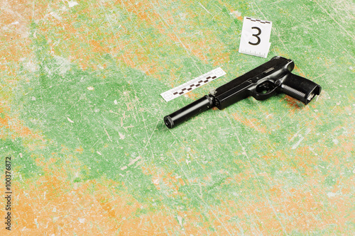 murder gun lying on the floor. crime scene photo