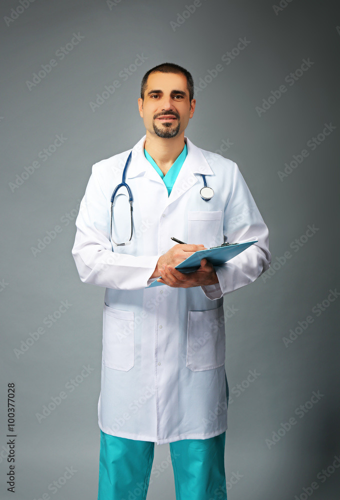 Portrait of a doctor with prescription board in hands on grey background Portrait of a doctor with prescription board in hands on grey background