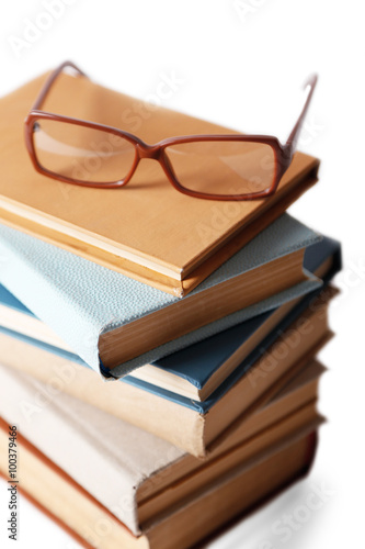Pile of books and eyeglasses on it isolated on white background