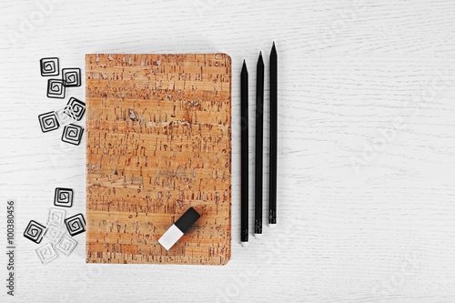 Notebooks with clips, eraser and pencils on a white table