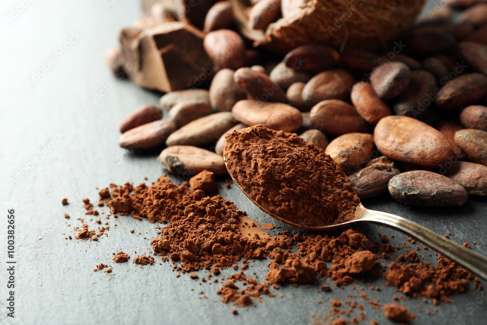 Bowl with aromatic cocoa beans and chocolate on grey background, close up Bowl with aromatic cocoa beans and chocolate on grey background, close up