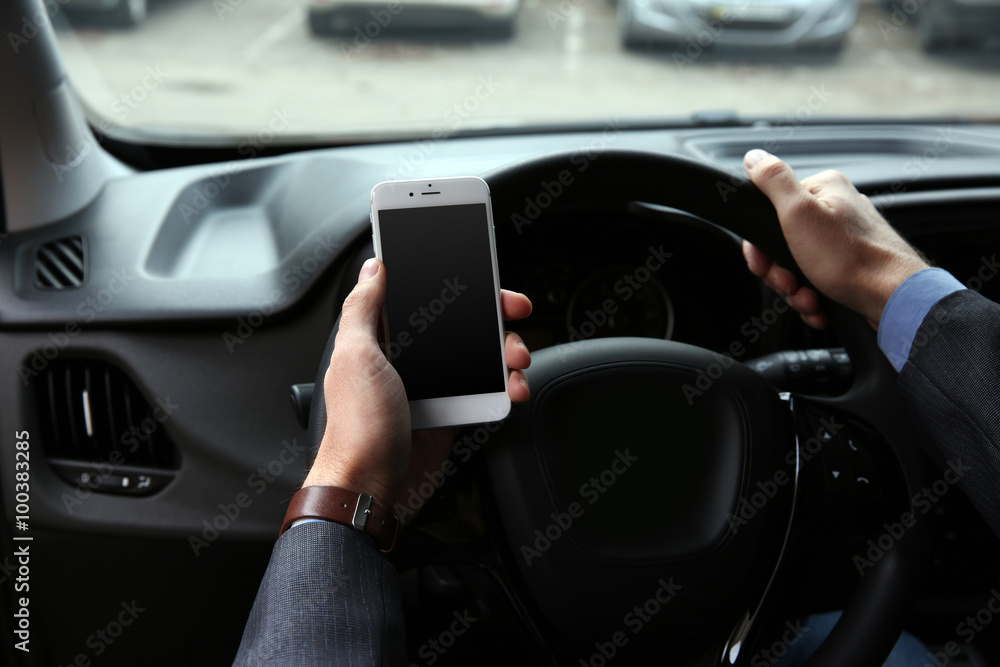 Man driver using smart phone in car