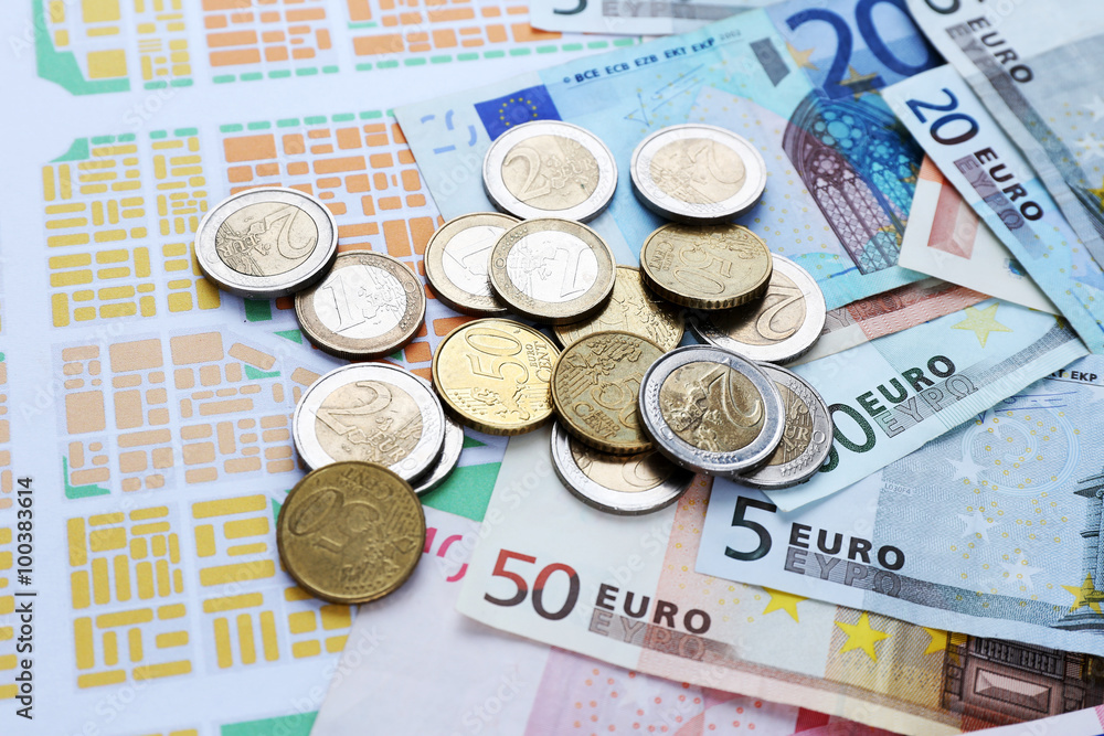 Euro coins and banknotes on map background Euro coins and banknotes on map background