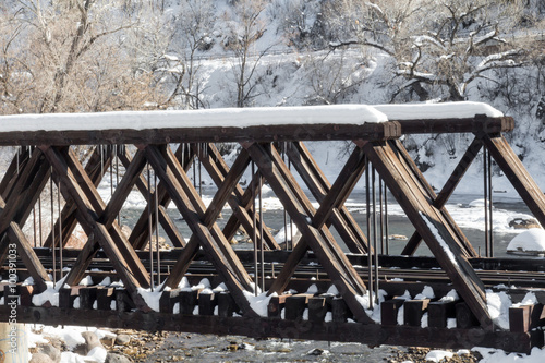 Snow covered wooden railway bridge over the Animas river