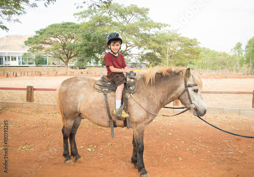 Little boy riding horse