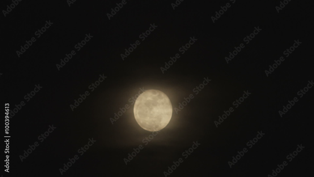 Wide shot of a full moon and clouds passing in front. Wide shot of a full moon and clouds passing in front.