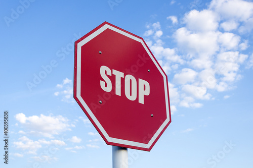 the white stop text in traffic sign on the red background with the cloud sky