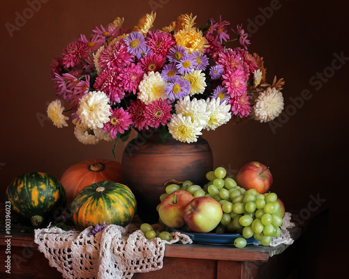 Autumn still life with a bouquet of chrysanthemums, grapes, appl