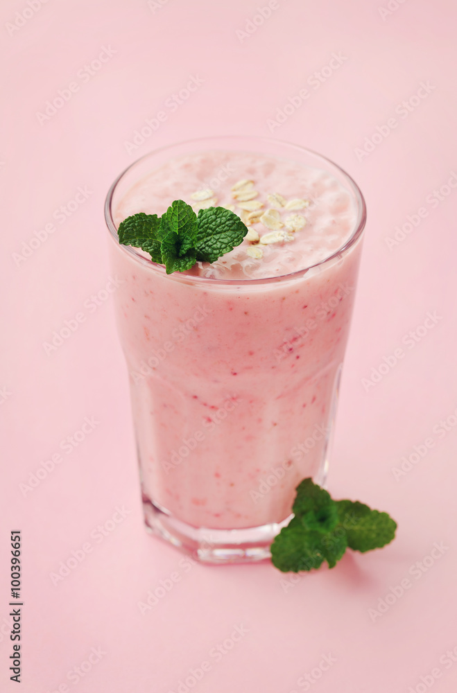 Berry smoothie or milkshake with oats decorated mint leaves on pink background, healthy and delicious breakfast Berry smoothie or milkshake with oats decorated mint leaves on pink background, healthy and delicious breakfast