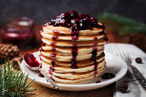 American pancakes or fritters served with strawberry and blueberry jam, delicious dessert for breakfast in winter, rustic style