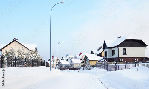 Snowy street with cottages in the winter village photo