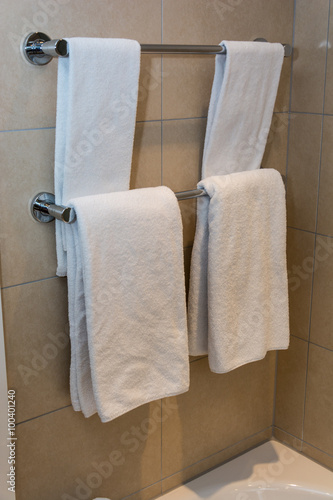 Bathroom Towels - white towels on a hanger prepared to use