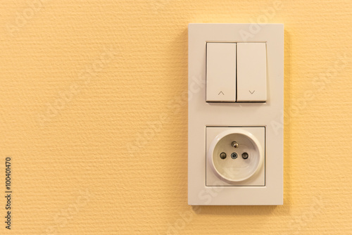 light switch and socket in frame on the wall