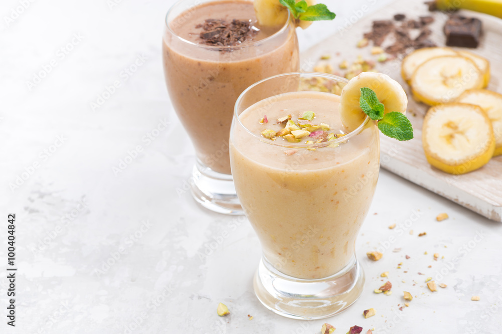 Banana and chocolate milkshake on white table Banana and chocolate milkshake on white table