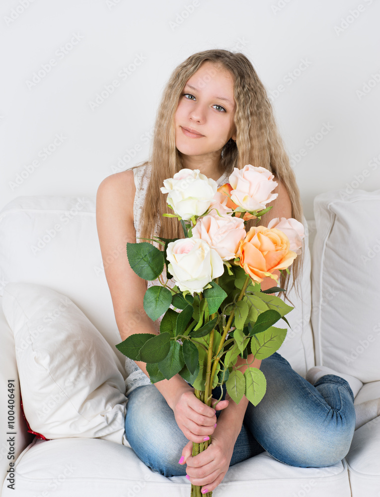 Girl sitting on a couch and holding a rose
