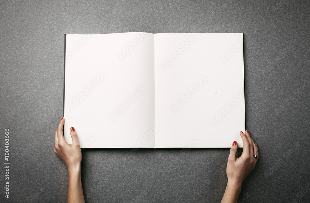 Female hands holding a big open book. Horizontal Female hands holding a big open book. Horizontal