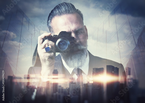 Portrait of bearded gentleman makes the photo on a retro camera. Double exposure.