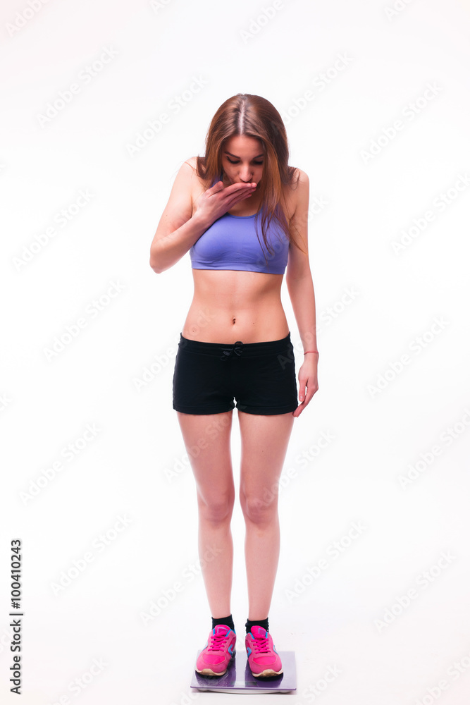 Sport girl Measuring Body Weight On Weighing Scale isolated on white background. Health concept Sport girl Measuring Body Weight On Weighing Scale isolated on white background. Health concept