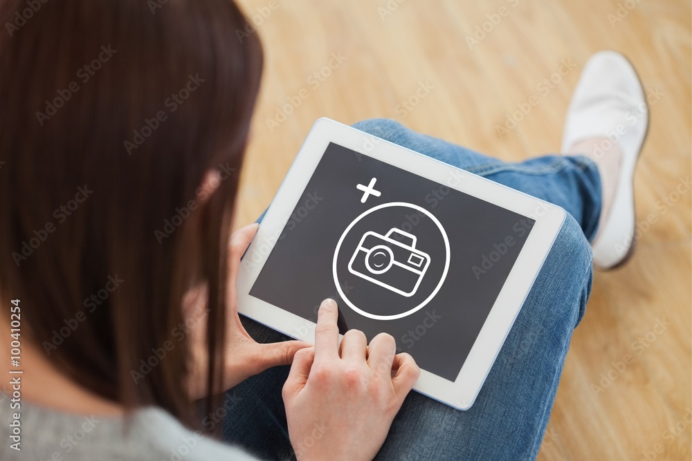 Obraz premium Composite image of girl using a tablet pc sitting on the floor