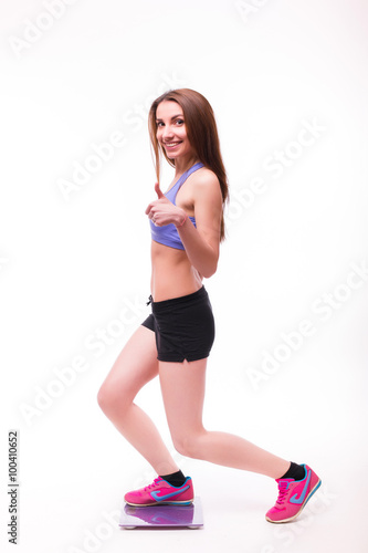 Fototapeta Naklejka Na Ścianę i Meble -  Sport girl Measuring Body Weight On Weighing Scale isolated on white background. Health concept