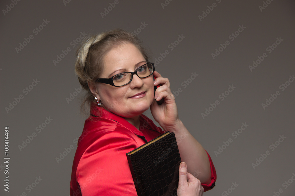 Successful business woman is not young in a suit with a notebook Successful business woman is not young in a suit with a notebook