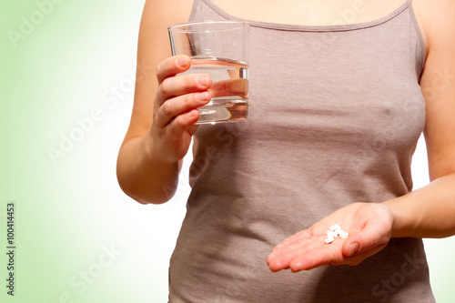 Canvastavla Frau hält Tabletten und ein Glas Wasser in der Hand