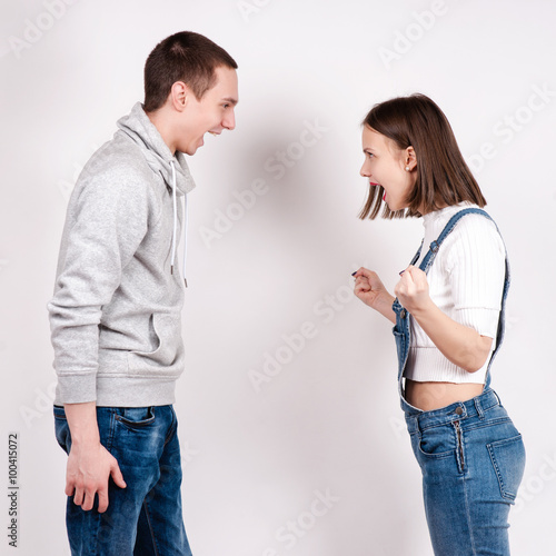 Portrait of an angry couple shouting each other against white background