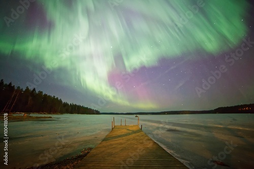 Northern lights and green aurora corona in the cold winter sky.