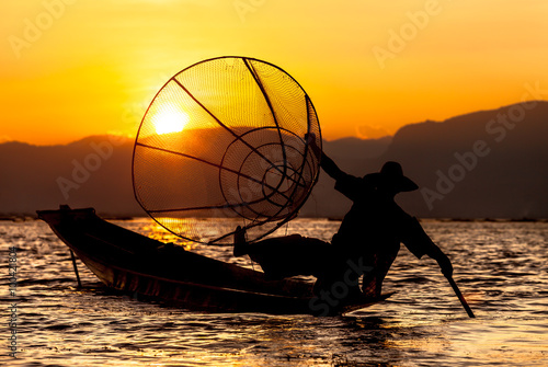 Sunset and fisherman on Inle Lake. Inle Lake with its leg-rowing Intha people is a major tourist destination in Myanmar.