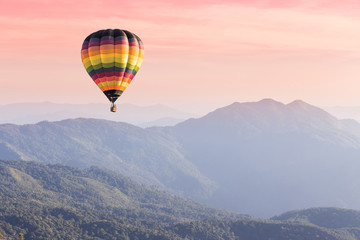 Acrylglasbilder Ballon Heißluftballon über Bergspitze im Sonnenuntergang  © littlestocker