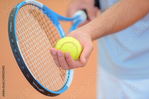 Closeup of man poised to serve at tennis