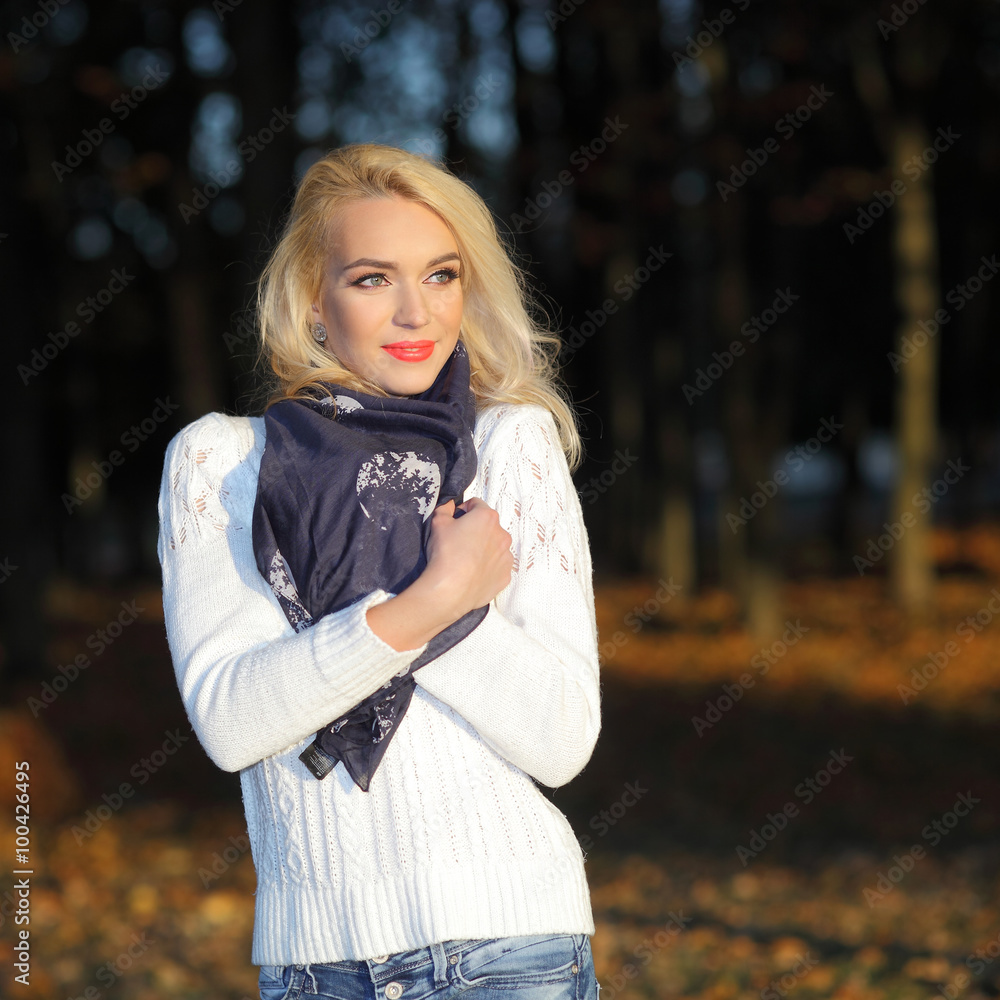beautiful blonde girl in a white sweater freezing in the autumn park beautiful blonde girl in a white sweater freezing in the autumn park