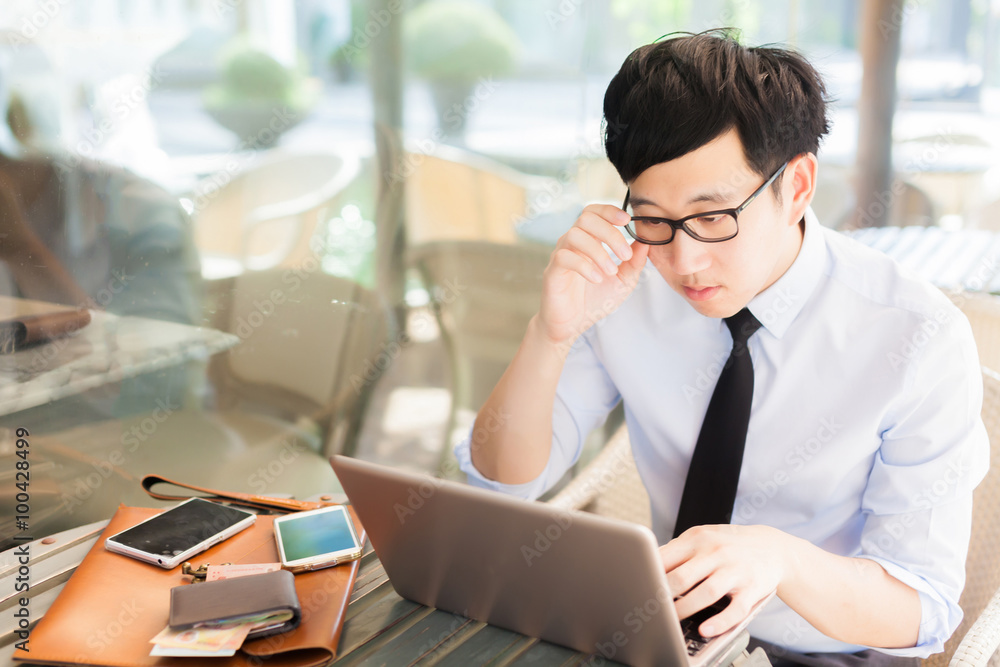 Young Asian businessman working on laptop in outdoor workplace Young Asian businessman working on laptop in outdoor workplace