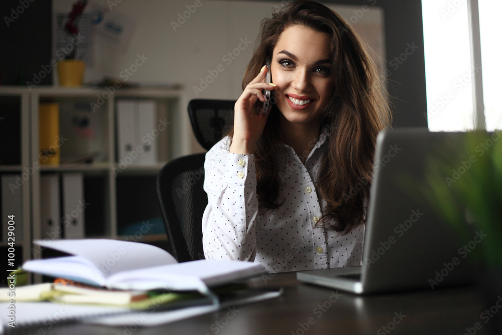 business concept - businesswoman talking on the phone in office