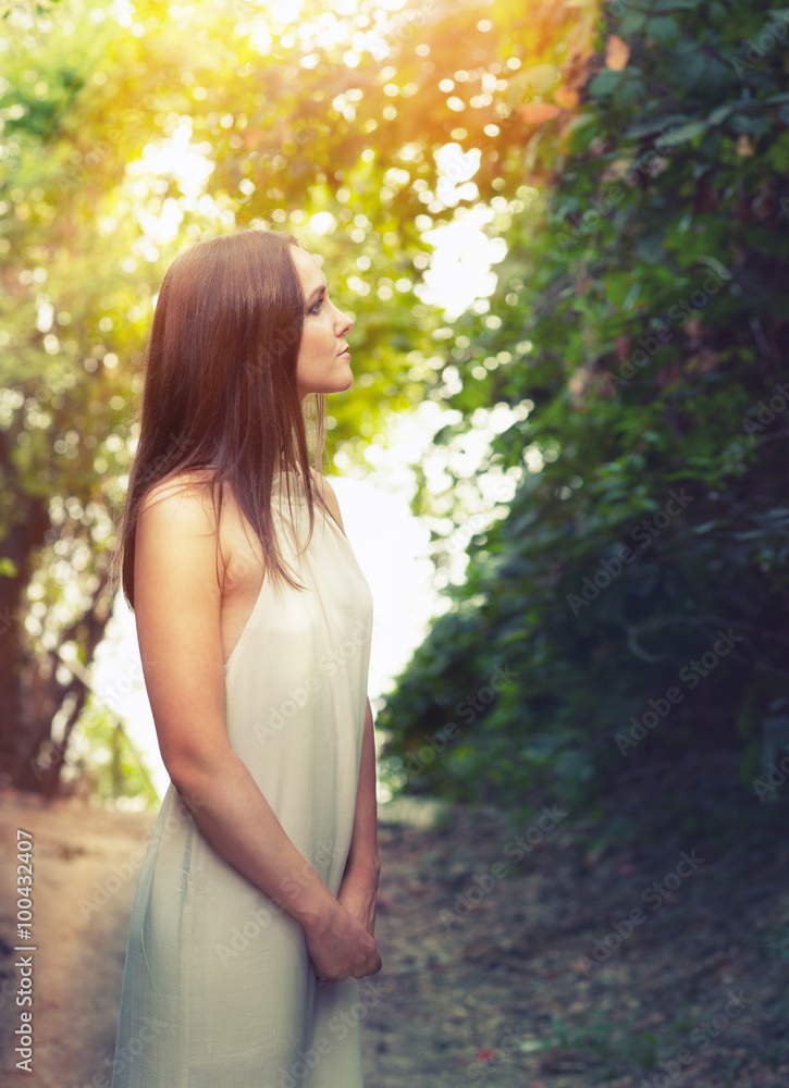 Portrait of a happy calm fashion woman dressed in white dress illuminated by sunlight. Portrait of a happy calm fashion woman dressed in white dress illuminated by sunlight.