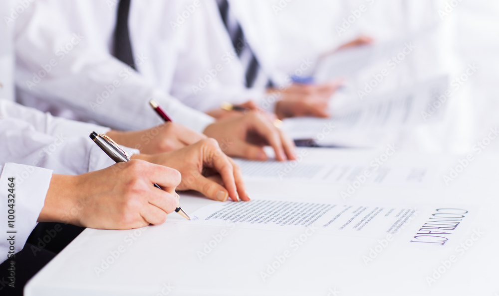 Close-up of male hands with pen over business document Close-up of male hands with pen over business document