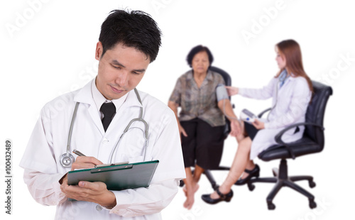 doctor writting medical report with female doctor measuring bloo