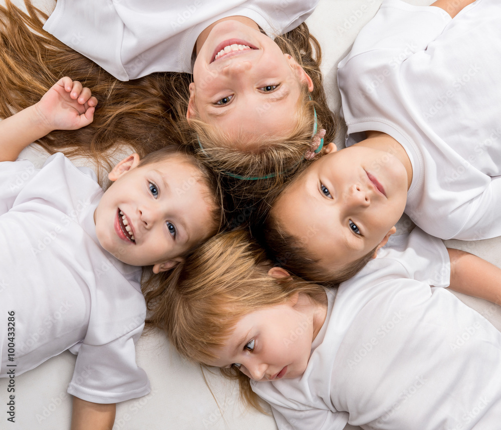 smiling children lying with their heads together