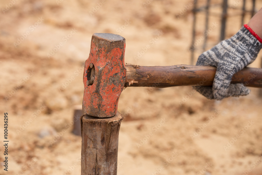 Worker hammering eucalyptus pointed Worker hammering eucalyptus pointed
