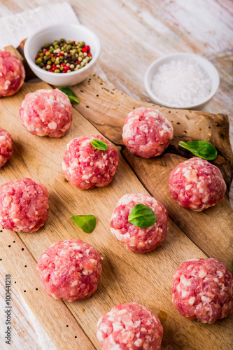 Raw meatballs of beef and pork on a wooden board