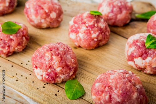 Raw meatballs of beef and pork on a wooden board