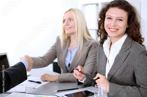 A group of business people at a meeting on the background of office. Business handshake