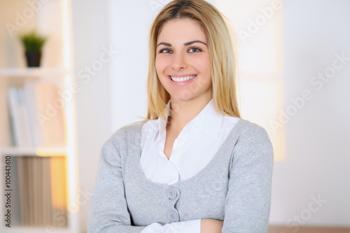 Portrait of young business woman on office background