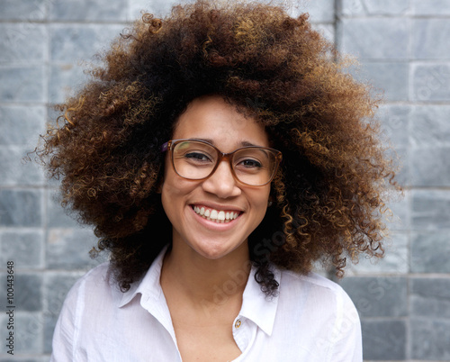 Smiling young african woman with afro and glasses