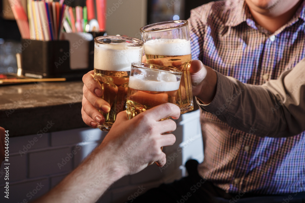 Happy friends drinking beer at counter in pub Happy friends drinking beer at counter in pub