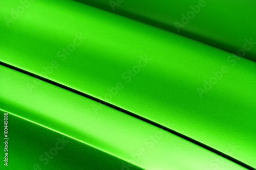 Surface of green sport sedan car metal hood, part of vehicle bodywork, steel gradient line pattern