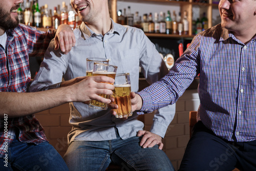 Photography Happy friends drinking beer at counter in pub