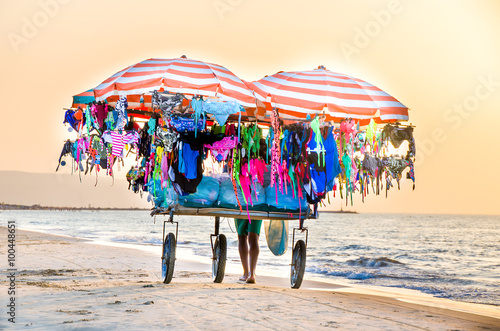 peddler on beach in Italy named vucumpra or vucumprà or vu cumprà or vu cumpra